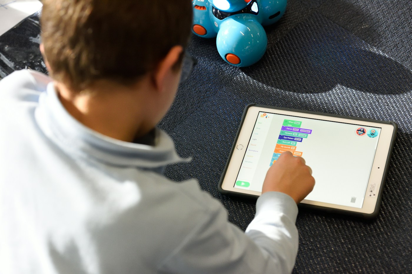 Home A child programming a robot using a tablet